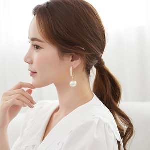 Elegant gold square zircon and imitation pearl drop earrings worn by a female model