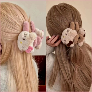 Close-up of plush Hello Kitty style hair claws in pink and brown on back of hair