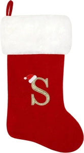 Close-up of red velvet Christmas stocking with white faux fur and golden sequin letter S