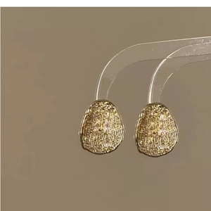 Detail of vintage gold plated oval stud earrings with unique brushed mesh metal texture