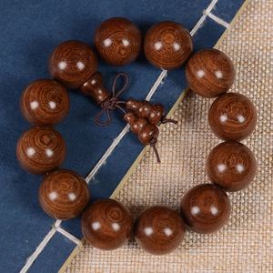 Deep brown sandalwood beads bracelet featuring a carved gourd pendant and fine wood grain