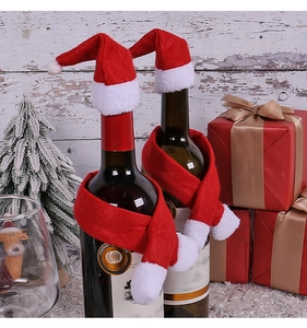 Mini Christmas hat and scarf set on wine bottles with festive holiday decor