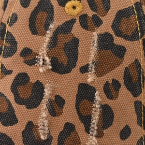 Macro detail of leopard print canvas baseball cap featuring distressed edges and eyelet