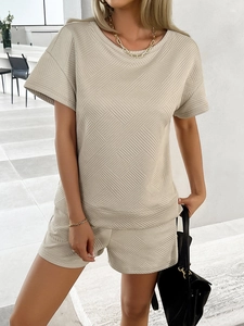Full view of women's beige knit two-piece set with geometric texture and crew neck design