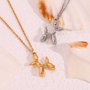 Artistic close-up of gold and silver balloon dog pendants on shell with water drops