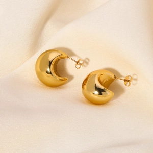 Polished 18k gold plated titanium steel crescent moon earrings on champagne silk fabric