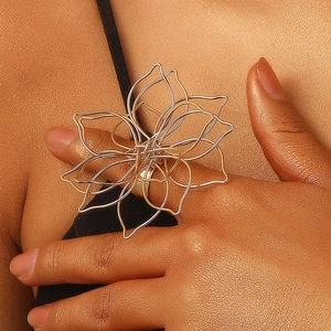 Detailed macro view of large golden wire-wrapped floral ring on model's finger