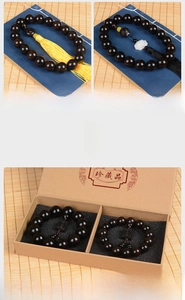 Macro shot of ebony wood prayer beads with lotus charms in a traditional gift box
