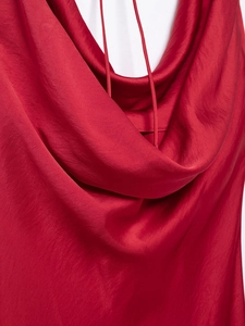 Détail de la robe en satin rouge avec col bénitier drapé et fines bretelles élégantes