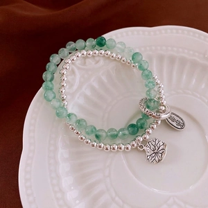 Double-layered beaded bracelet with green jade and silver beads featuring a leaf charm