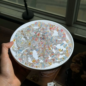 Détail d'un bracelet en perles de pierre colorées avec de petites fleurs en métal sur plat