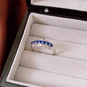 Détail macro d'une bague couronne élégante en argent avec des pierres de zircon bleu foncé