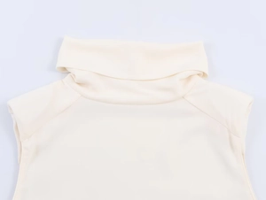 Detail shot of the cream high neck sleeveless top showing pleats and shoulder stitching