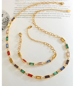 Detail of a 18K gold bracelet with colorful rectangular zircons on an open book