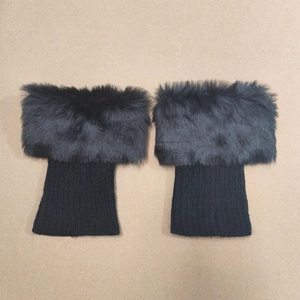Close-up of black faux fur and knit leg warmers showing texture and plush material