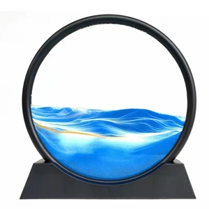 Macro shot of circular moving sand art with blue and white flowing sand and golden accents