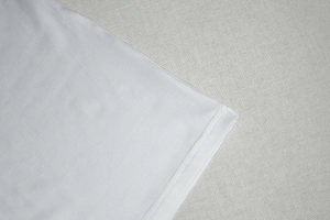 Gros plan sur la couture double aiguille de l'ourlet d'une robe blanche élégante