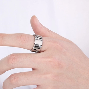 Detail of silver Cuban link titanium ring showing the hollow chain design on finger