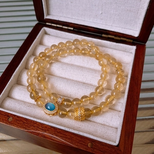 Detail of Rutilated Quartz bracelet with blue zircon oval pendant and gold accents
