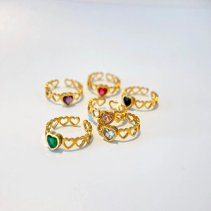 Close-up of six gold-plated heart rings with assorted colorful zircon stones