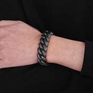 Detail of vintage distressed stainless steel Cuban link bracelet on a male wrist