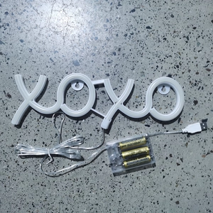 Detail view of XOXO LED neon sign with dual AA battery box and USB power cable