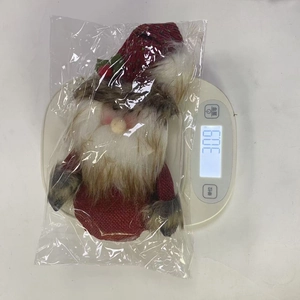 Detail of Christmas gnome plush doll in packaging on a scale showing 30.9g weight