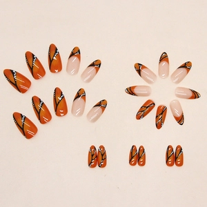 Handmade almond press-on nails with bright orange and black butterfly wing pattern design