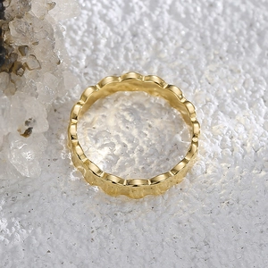 French minimalist gold wave ring with a polished scalloped edge on white crystal