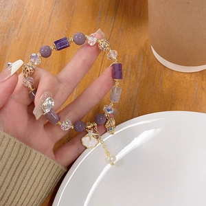 Detail of lavender crystal bead bracelet with starfish and seashell charms on wrist