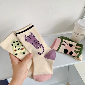 Detailed close-up of cute cartoon cat and rabbit jacquard patterns on cotton crew socks