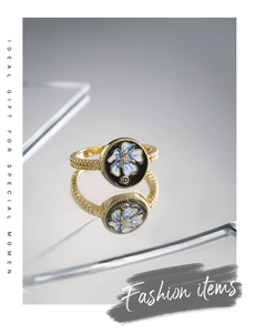 Detailed macro shot of vintage gold ring with black enamel and blue flower inlay