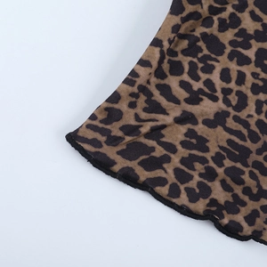 Macro shot of leopard print knit top featuring ruffle hem with black stitching details