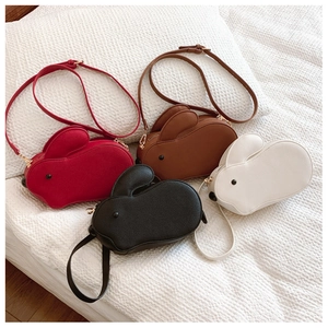 Détail à plat de sacs bandoulière lapin mignons en cuir rouge, marron, noir et blanc