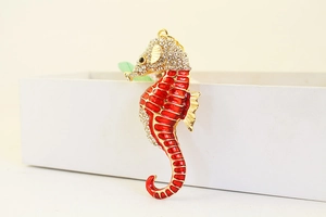 Detail of seahorse pendant with red enamel coating and crystal rhinestones on gold base