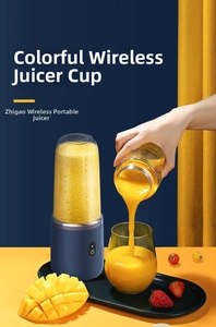 Macro shot of portable cordless blender pouring fresh fruit juice into a glass cup
