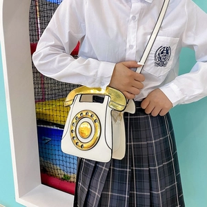Detail of vintage rotary telephone crossbody bag with metallic gold handset and dial pad