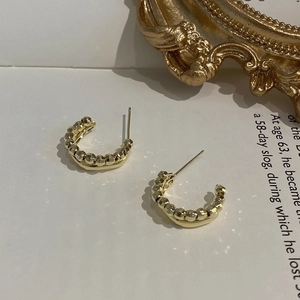 Orecchini a perno a forma di C in oro 18 carati con perni in argento su sfondo retrò