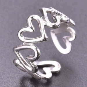 Macro shot of silver hollow heart-shaped stainless steel open ring with interlocking pattern
