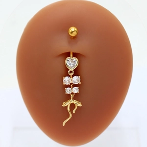 Golden belly ring with crystal heart and bow pendant on a realistic body model
