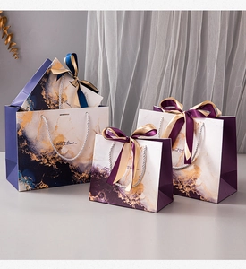 Detail of royal blue marble gift bags with golden accents and silk ribbon bows