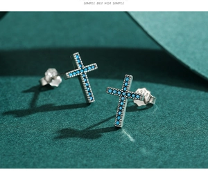 Macro shot of S925 sterling silver cross stud earrings with inlaid turquoise stones