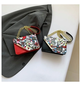 Close-up of stylish graffiti print chain crossbody bags in red and black leather