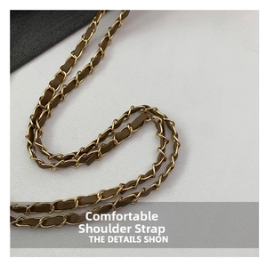 Detail of woven chain strap featuring gold metal links and olive green leather texture
