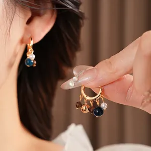 Vintage style hoop earrings featuring pearl and tiger eye beads in a boho tassel design