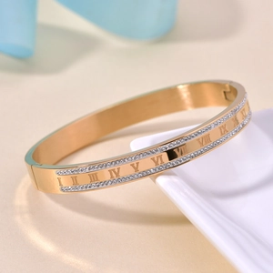 Macro detail of 18K gold-plated stainless steel bangle with Roman numerals and rhinestones