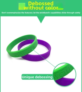 Detail of custom debossed text on green and purple silicone wristbands with macro view