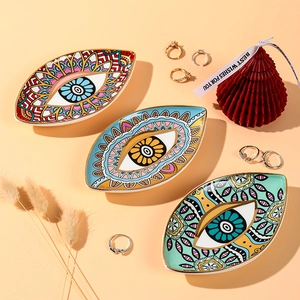 Detailed top view of ceramic Evil Eye jewelry trays with mandala patterns and gold rings