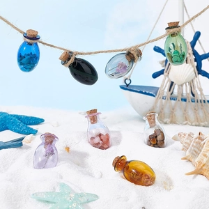 Mini oval colorful glass wishing bottles with cork stoppers and crushed crystals on sand