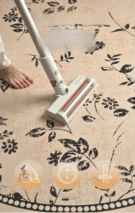 Detail of round beige floral rug compatible with vacuum cleaner and robot mop